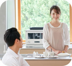 キッチンで笑顔で会話する夫婦の画像